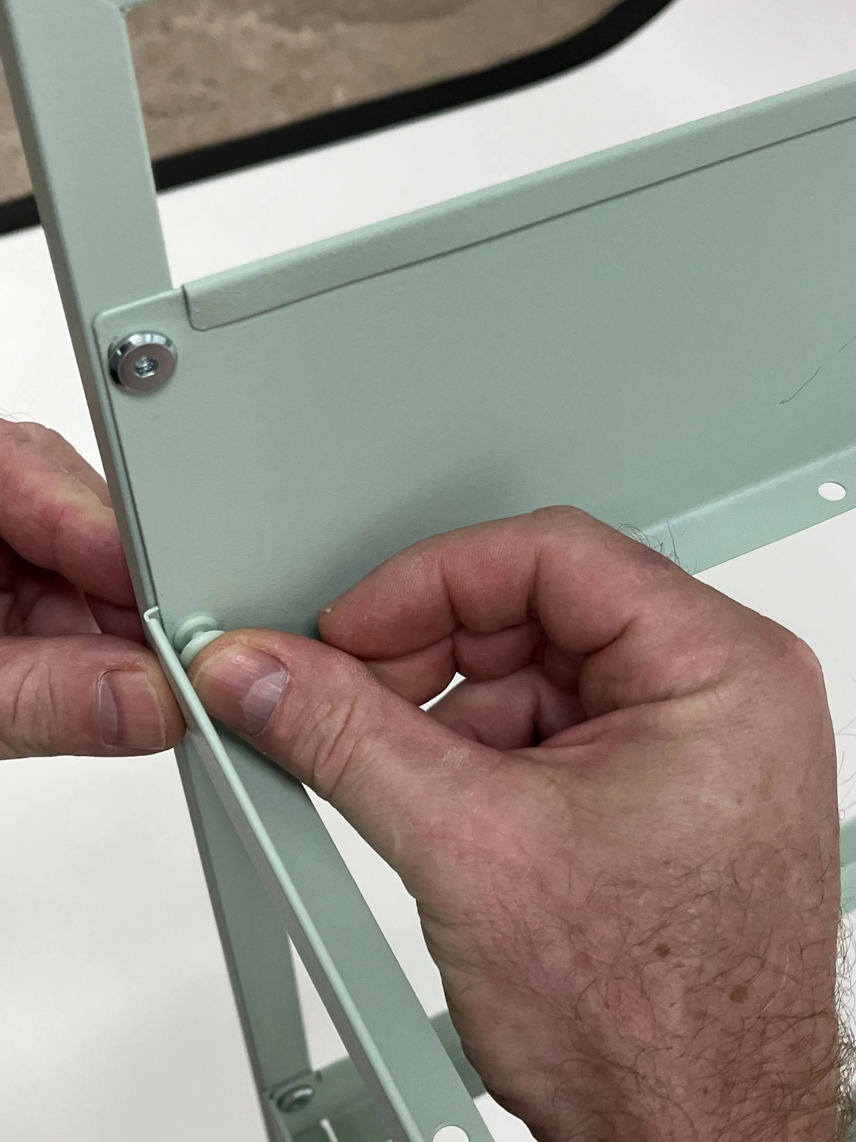 Use provided plastic pieces to fix the top tray in the new holes