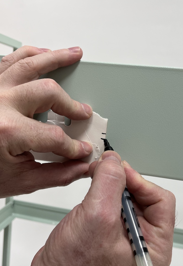 Measure the height of the front hole and mark a hole matching it at the horizantal center of the back.